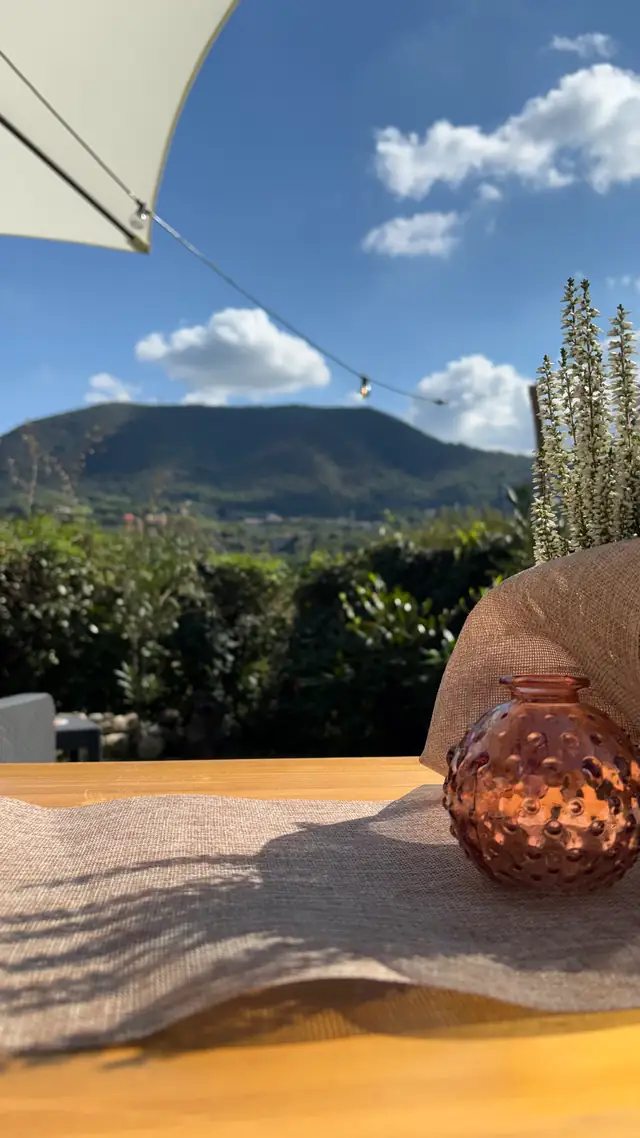 Tavolo con vaso in vetro colorato e vista sui colli
